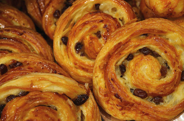 istock Heap of Delectable Raisin Cinnamon rolls lined up on the Tray, Selective Focus 905933108