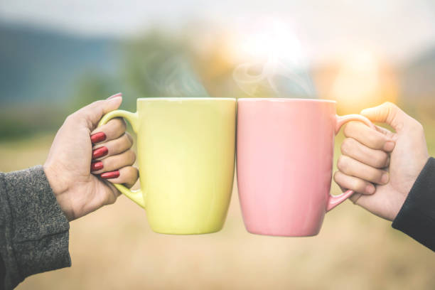 istock friends enjoy drinking hot drink together cheers for two cup 905933384