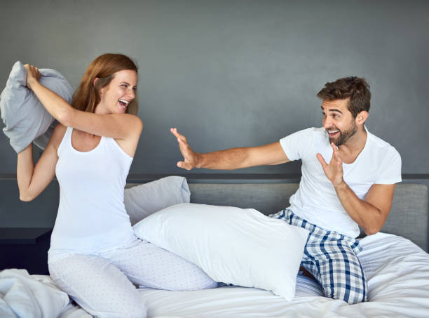 ¡prepárate para ser derrotado por el campeón de lucha de almohadas! - bed couple pillow fight men fotografías e imágenes de stock