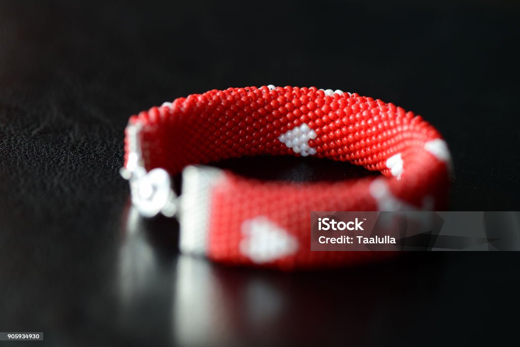 Valentine's Day red beaded bracelet on a dark background close up Art Stock Photo