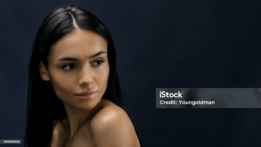 Close up portrait of a young attractive woman, looking away Black Hair Stock Photo