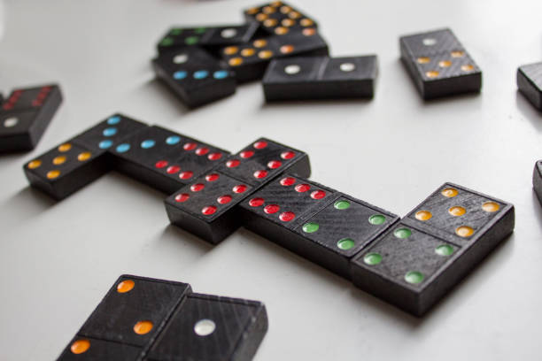 istock Black dominoes with colorful dots 905937532