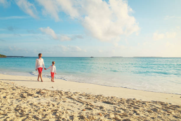 istock father and son walking on beach 905949616
