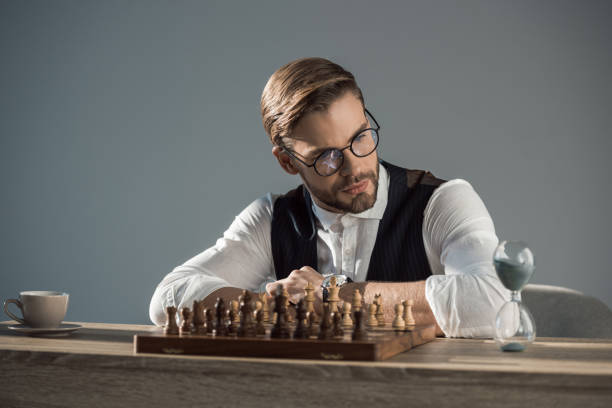istock focused young businessman looking at sand clock while playing chess 905953840