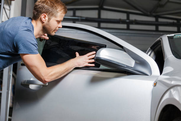 istock Applying tinting foil onto a car window 905956972
