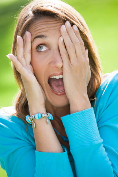istock woman in summer who is hiding her face behind her hands 905960194