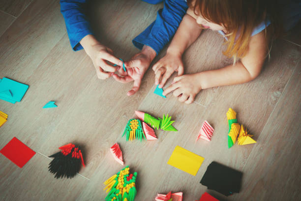 istock kids making origami crafts with paper 905960698