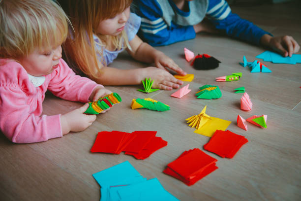 istock kids making origami crafts with paper 905960760