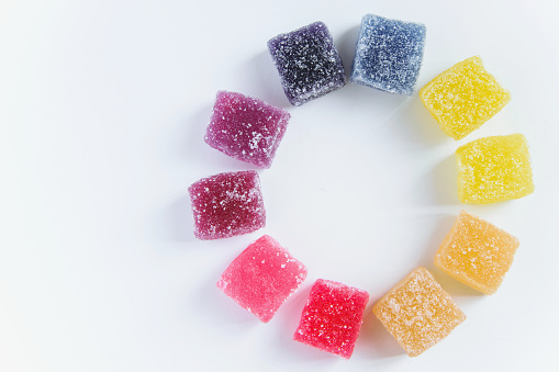 Sweet background by yummy jelly candies on white background with space for text