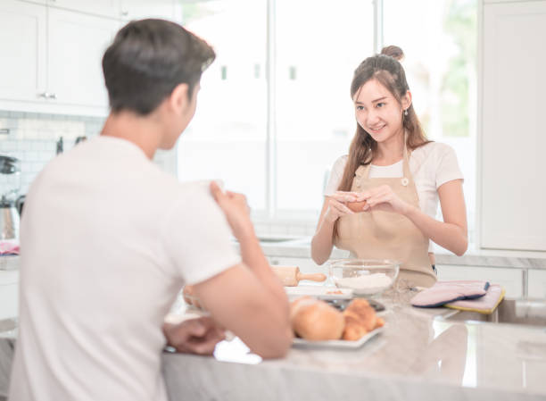 istock Man drinks coffee while a woman prepares a meal 905963474