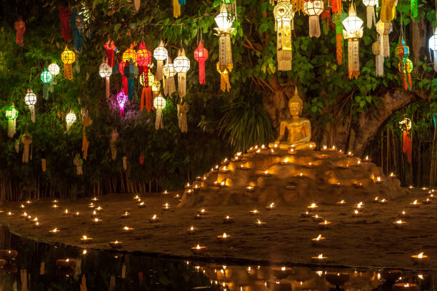 istock Buddha statue surrounded by candles and colorful lanterns. 905968956