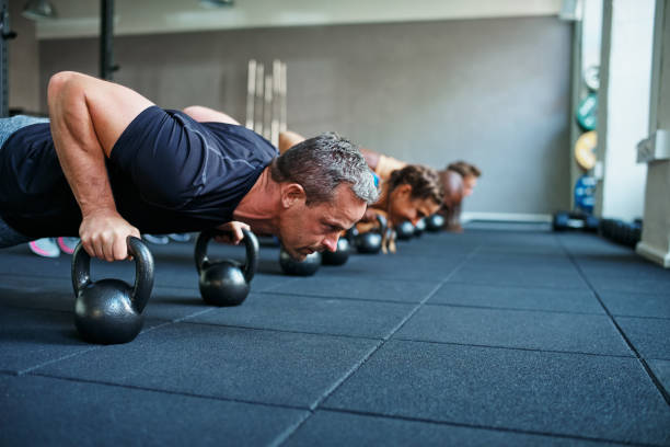 istock Fit people doing pushups on weights in a gym class 905971452