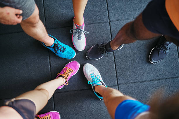 Diverse people wearing running shoes standing in a gym stock photo