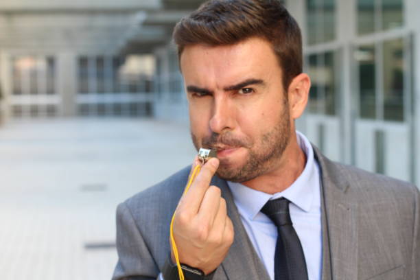 Stern man blowing the whistle in office