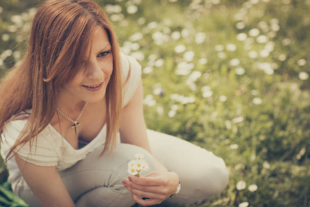 Happy girl pick daises in nature