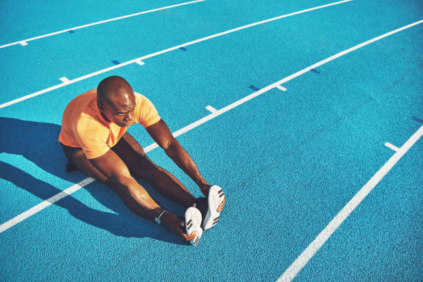 istock Young athlete stretching on a running track before training 905978780