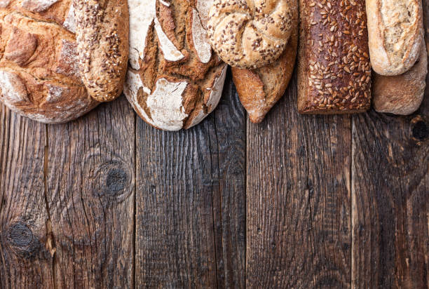 istock Delicious fresh bread on wooden background 905978936