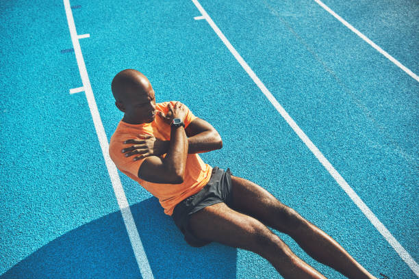 istock Young African athlete doing crunches on a running track 905981862