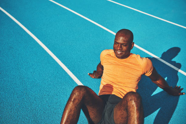 istock Fit young runner sitting on a running track after training 905982660