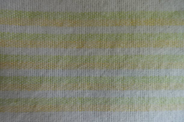 istock Green and yellow horizontal stripes on white fabric from above 905983180