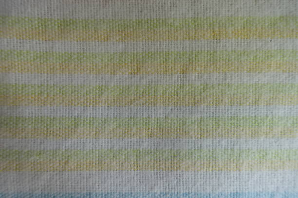 istock Yellow and green horizontal stripes on white fabric from above 905983314