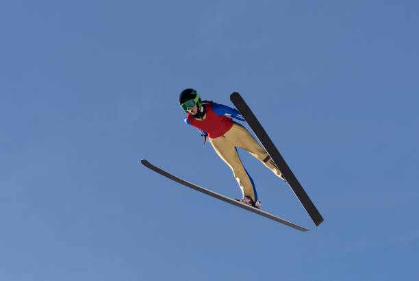 front view of female ski jumper in mid-air - telemark skiing fotos imagens e fotografias de stock