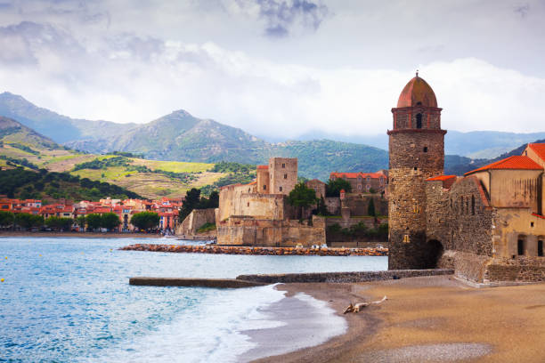 Picturesque Collioure Church of Notre-Dame de Anges and promenade in picturesque harbor of Collioure collioure stock pictures, royalty-free photos & images