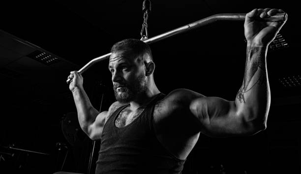 istock Professional athlete performs an exercise in the gym. Pulls the bar to the back of the head. 905989884