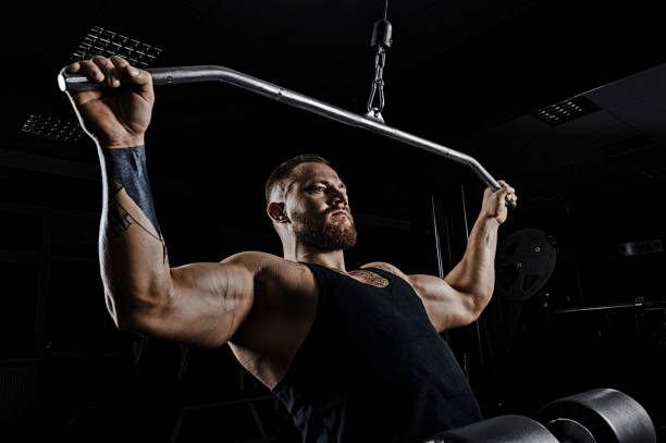 istock Professional athlete performs an exercise in the gym. Pulls the bar to his chest. 905989902