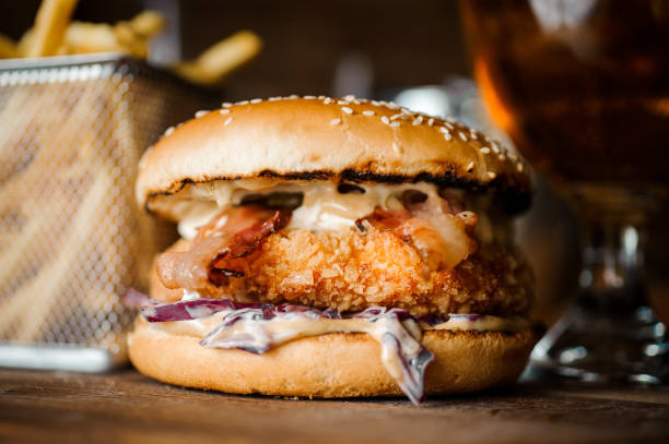 istock Tasty burger with cutlet, cheese and vegetables served on a wooden table 905989934