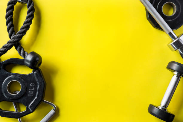 attrezzatura da palestra sportiva su sfondo giallo - attrezzatura per esercizio fisico foto e immagini stock