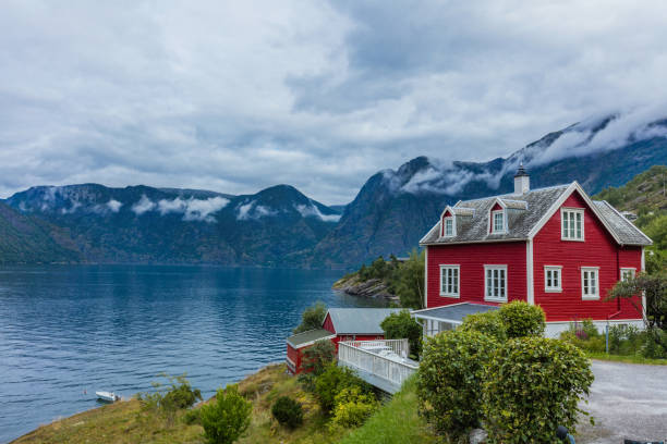 istock Wooden red cottage. Stone snowy mountains. Norway 906005900