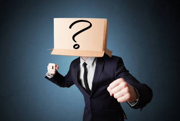 istock Businessman gesturing with a cardboard box on his head with question mark 906007796