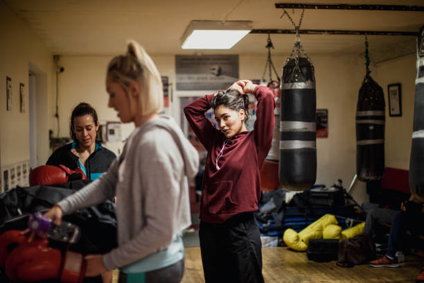Women After Their Training Session Three women in a boxing gym standing together as they pack up their things after a training session. They look positive women boxing sport exercising stock pictures, royalty-free photos & images