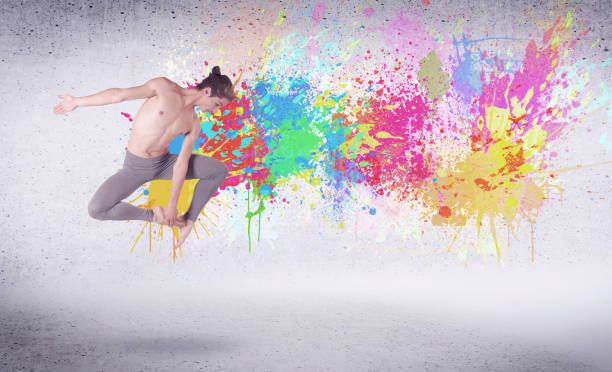 istock Modern street dancer jumping with colorful paint splashes 906020286