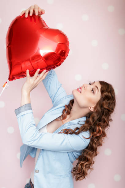 istock woman with heart shaped air balloons 906020622