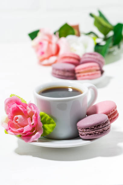 istock macaroon cookies, cup of coffee and flowers on white table 906021556