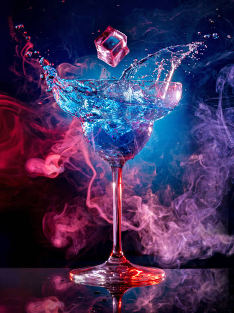 ice falling into splashing cocktail on multicolored background - drink ice splashing spray imagens e fotografias de stock