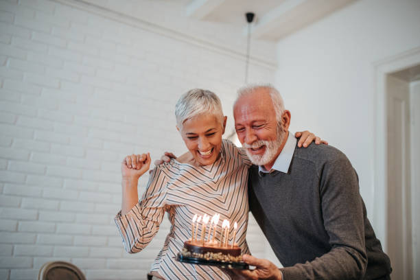 Celebrating special day together Mature couple celebrating holding a birthday cake woman birthday cake stock pictures, royalty-free photos & images