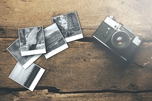 istock camera and photos on wood table 906044056