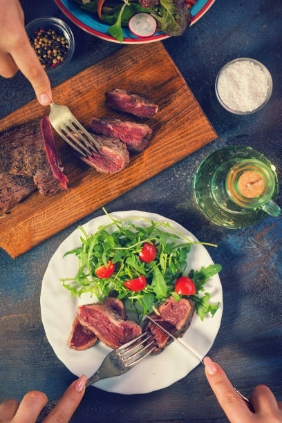 istock Young Women Eating Juicy Beef Steak 906045054
