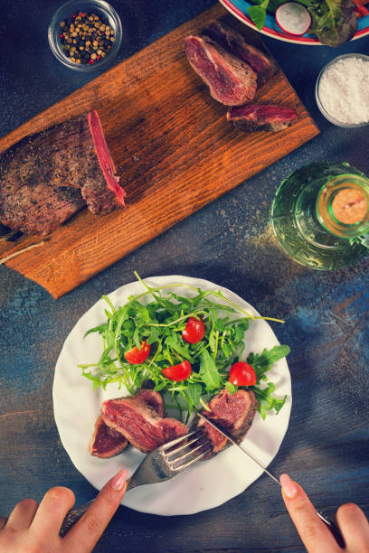 istock Young Women Eating Juicy Beef Steak 906045136