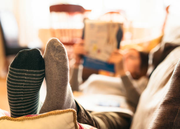 istock Feet up and reading a magazine at the weekend 906079142