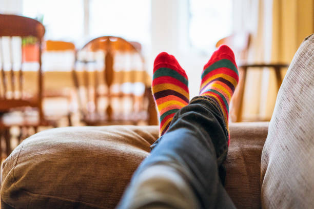 vớ stripey trên đôi chân thư giãn trên ghế sofa - quan điểm cá nhân hình ảnh sẵn có, bức ảnh & hình ảnh trả phí bản quyền một lần