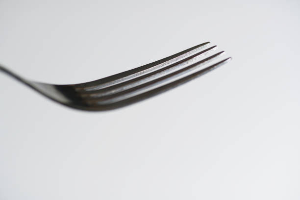 Detail of a fork fork photographed in front of white background in the studio