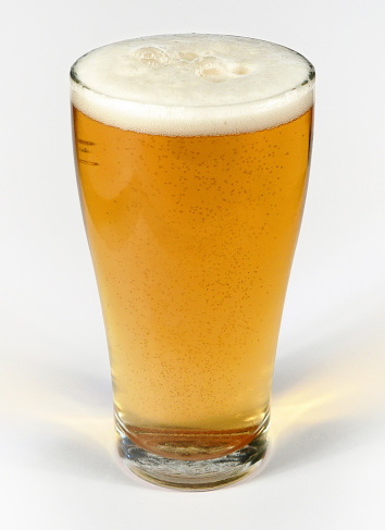 A glass of beer with froth head on a white background with clipping path.  Please see my portfolio for other food and drink images. 