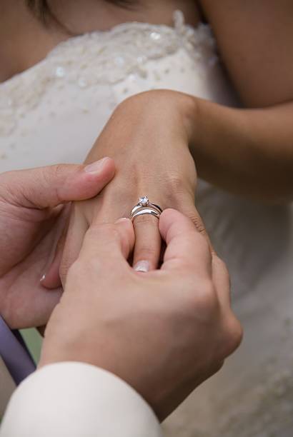 istock Bridegroom putting wedding ring on bride's finger 90612465