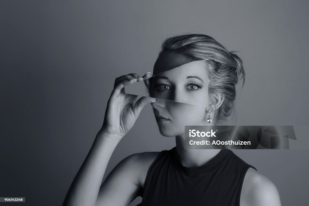 Conversión creativa de una mujer sosteniendo un trozo de espejo roto y los ojos de otra conversión artística de la exposición - Foto de stock de Espejo libre de derechos