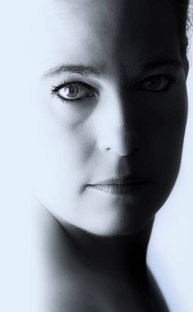 istock High key portrait of a woman with empty expression on her face and a shadow on the other side 906143276