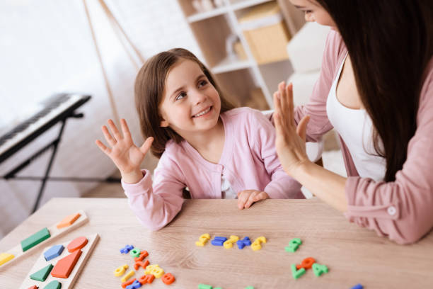 istock A young woman is teaching a little girl a math. 906147058